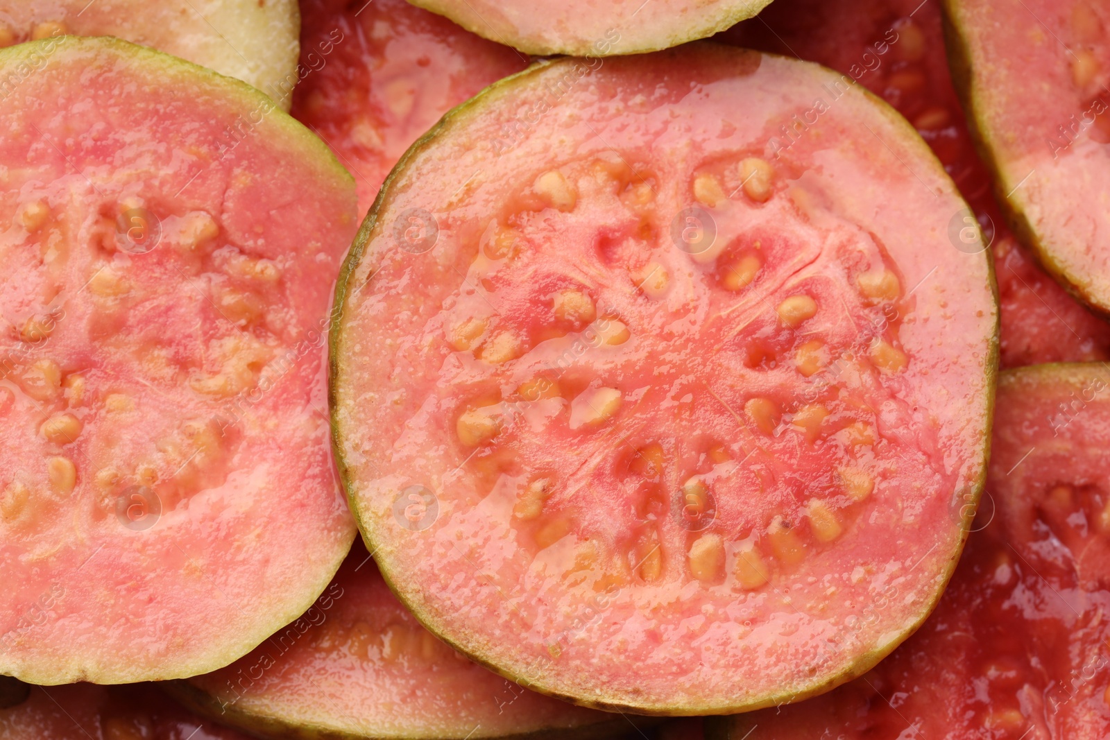 Photo of Many juicy slices of guava as background, above view