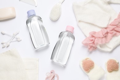 Photo of Baby oil, clothes and bath accessories on white background, flat lay