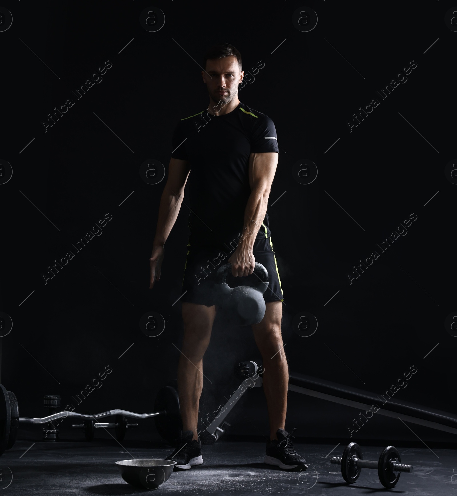 Photo of Man training with kettlebell on black background