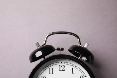 Photo of Black alarm clock on grey background, top view
