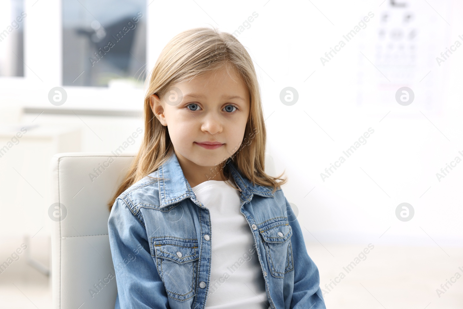 Photo of Portrait of cute little girl at ophthalmologist office. Eye examination