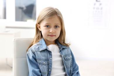 Photo of Portrait of cute little girl at ophthalmologist office. Eye examination