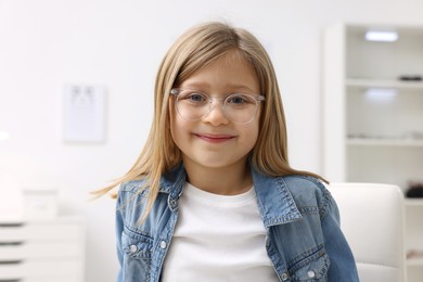 Little girl trying glasses at ophthalmologist office