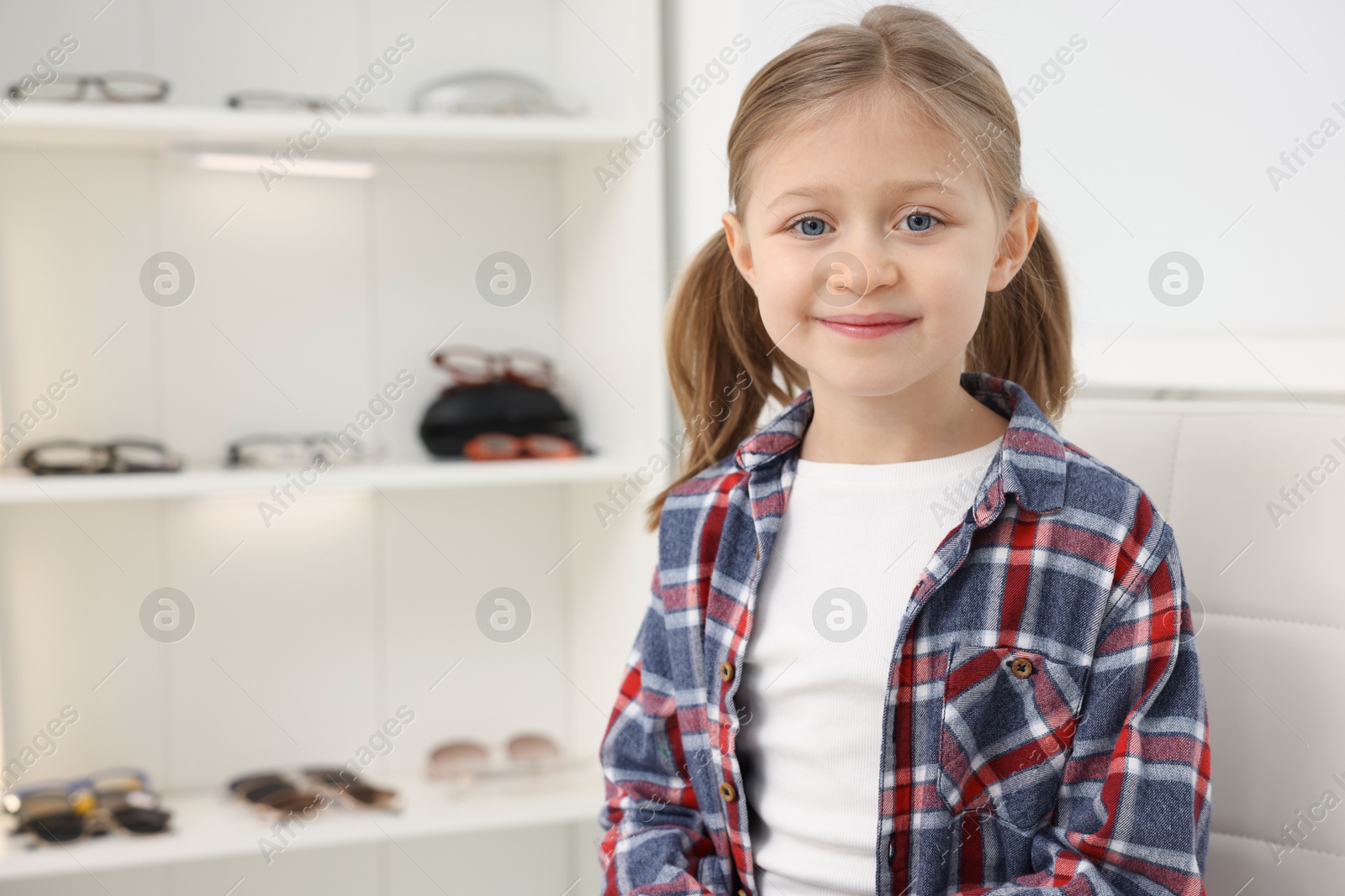 Photo of Little girl at ophthalmologist office, space for text. Eye examination