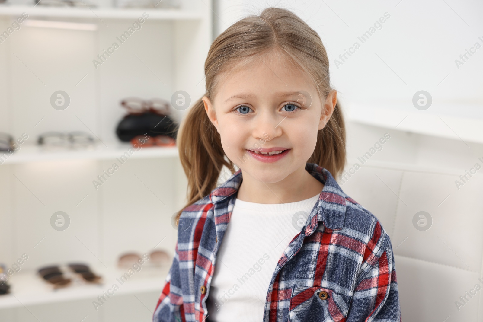 Photo of Little girl at ophthalmologist office, space for text. Eye examination