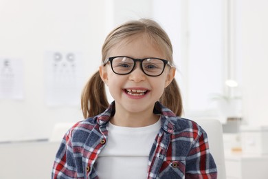 Little girl trying glasses at ophthalmologist office