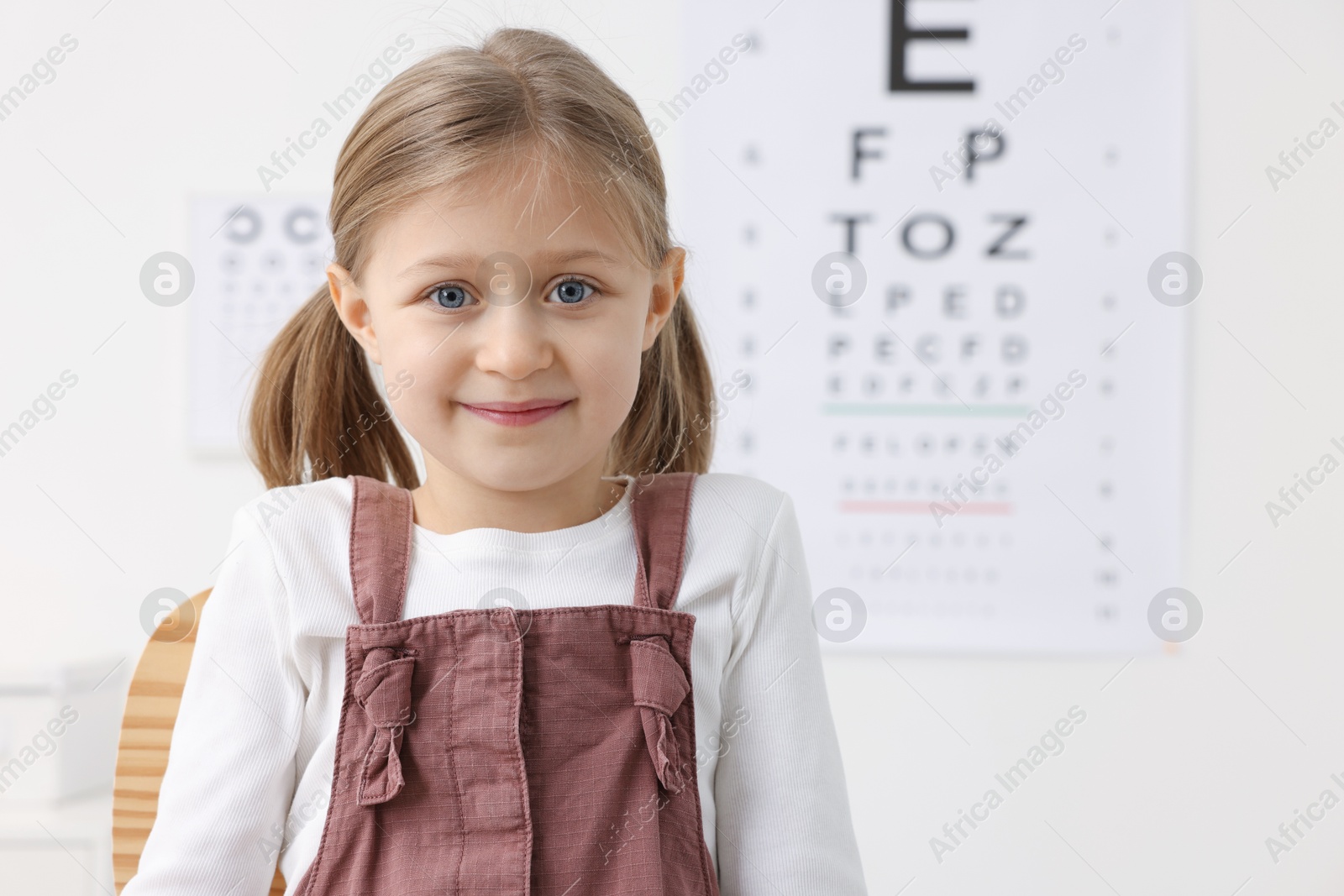 Photo of Portrait of little girl at ophthalmologist office, space for text. Eye examination