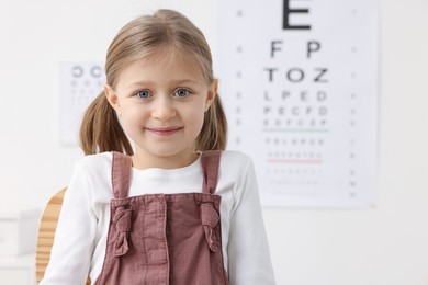 Photo of Portrait of little girl at ophthalmologist office, space for text. Eye examination