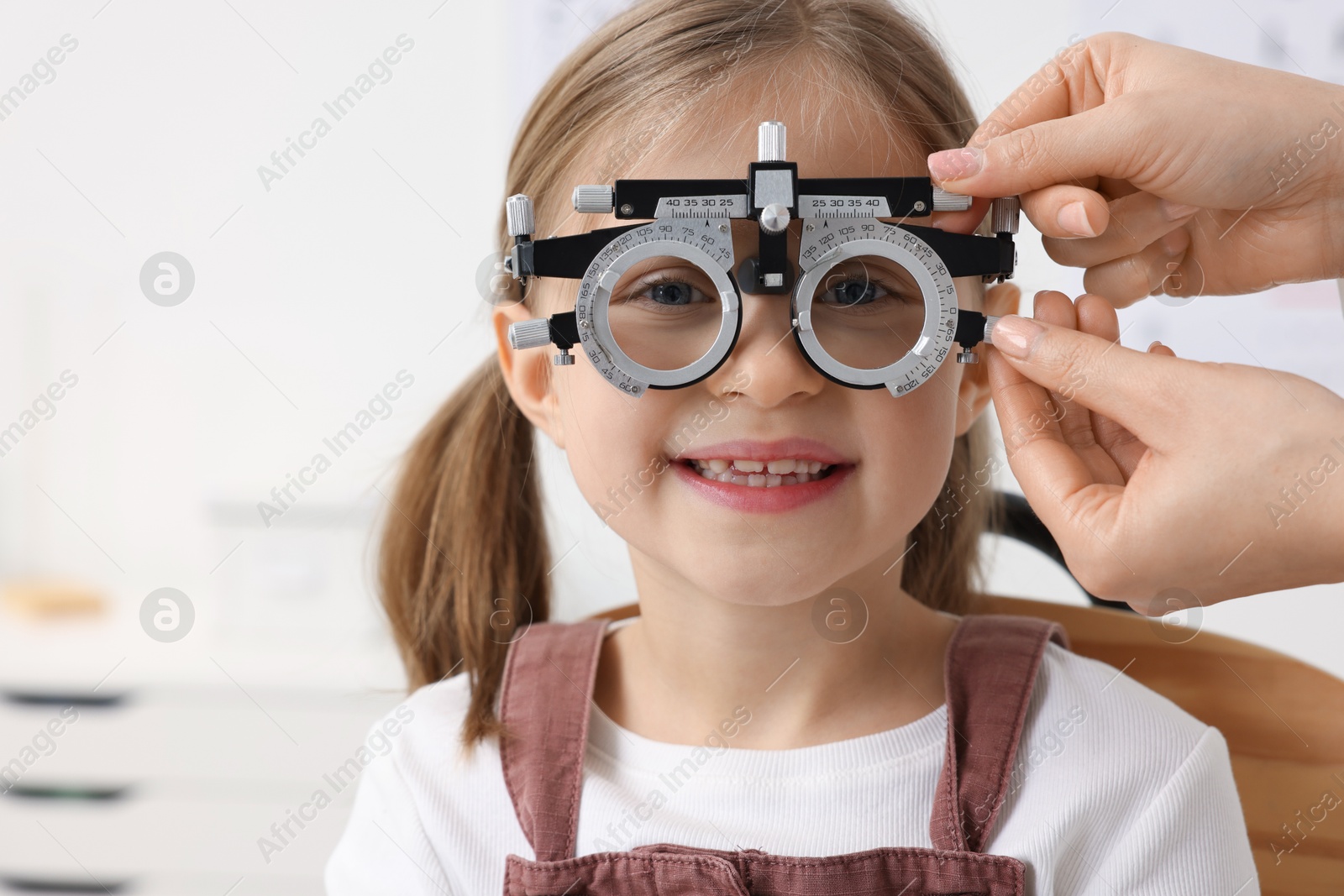 Photo of Ophthalmologist examining patient's vision with trial frame in clinic, closeup