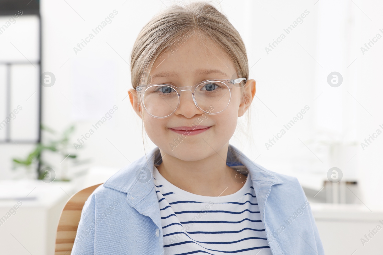 Photo of Little girl trying glasses at ophthalmologist office