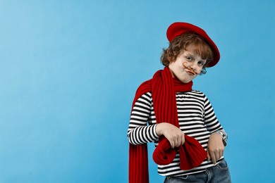 Photo of Cute boy in mime costume on light blue background, space for text. Surprise party