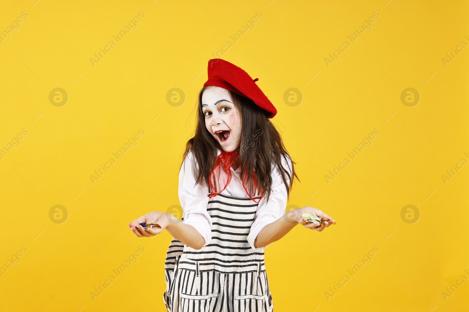 Photo of Emotional girl dressed like mime with confetti on yellow background. Surprise party