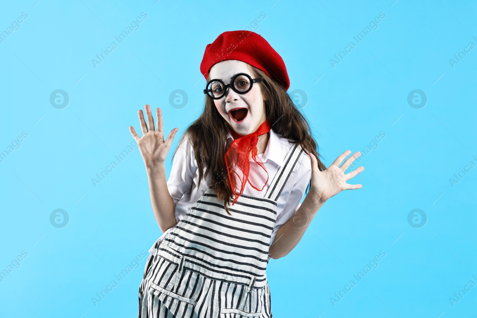 Photo of Emotional girl dressed like mime on light blue background. Surprise party