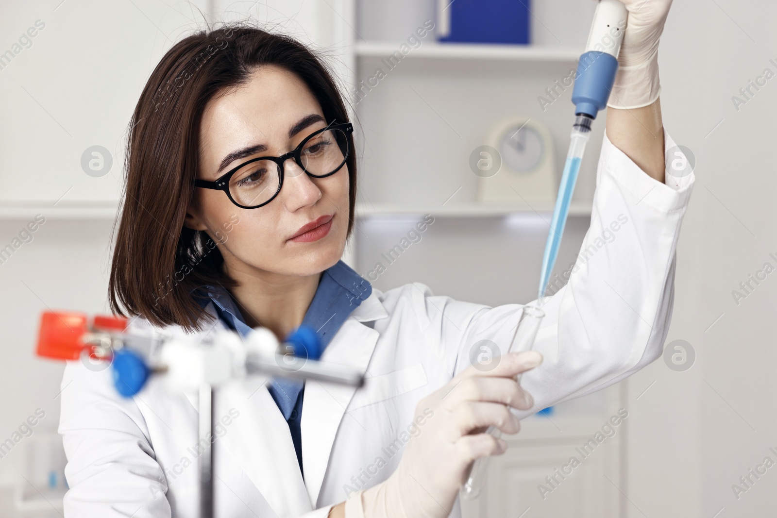 Photo of Scientist with micropipette and test tube working in laboratory