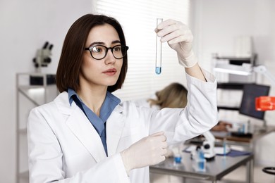 Photo of Scientist with test tube working in laboratory