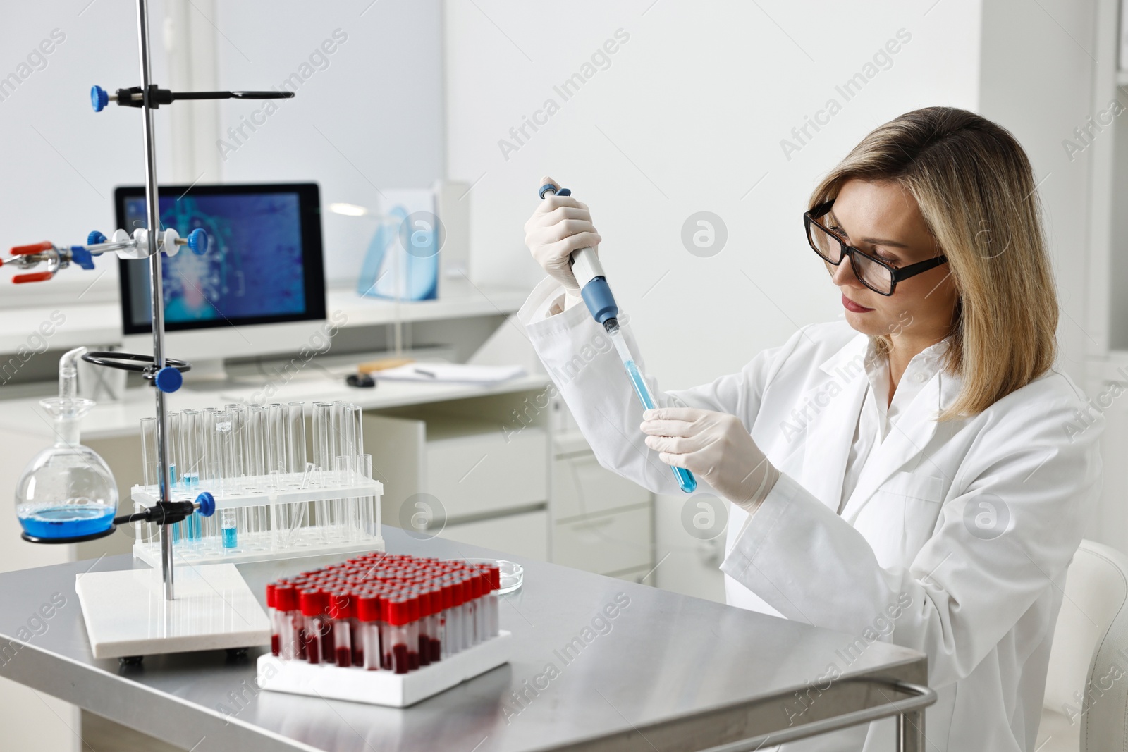 Photo of Scientist with micropipette and test tube working in laboratory