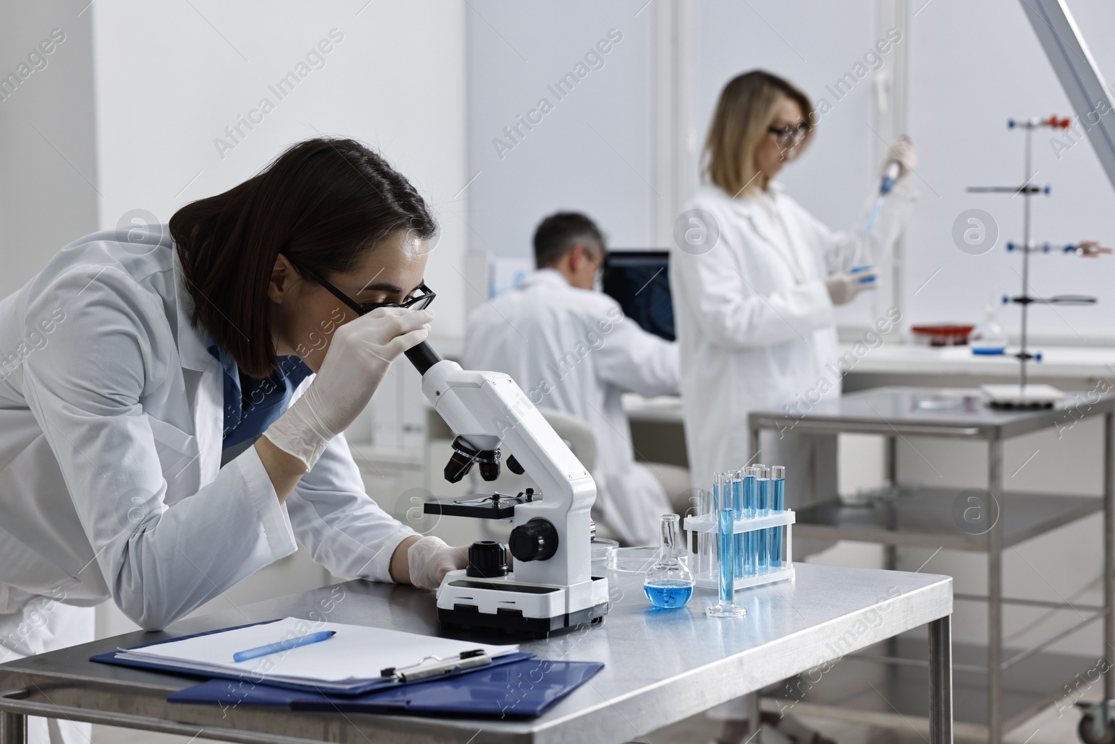 Photo of Scientist working with microscope at table in laboratory