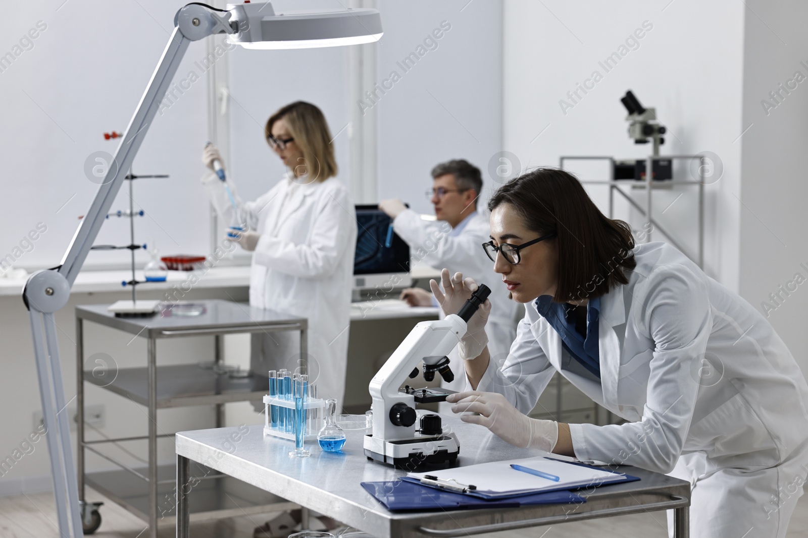 Photo of Scientist working with microscope at table in laboratory