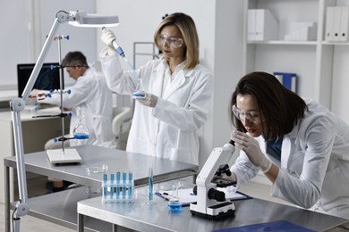 Scientists working with samples at table in laboratory