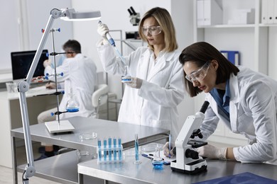 Photo of Scientists working with samples at table in laboratory