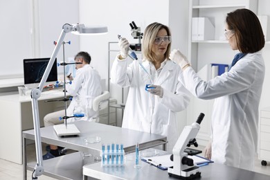 Photo of Scientists working with samples at table in laboratory