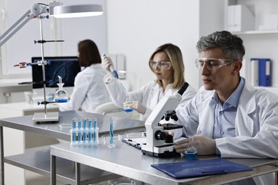 Photo of Scientists working with samples at table in laboratory