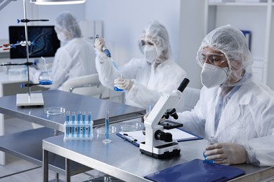 Photo of Scientists wearing protective suits while working in laboratory