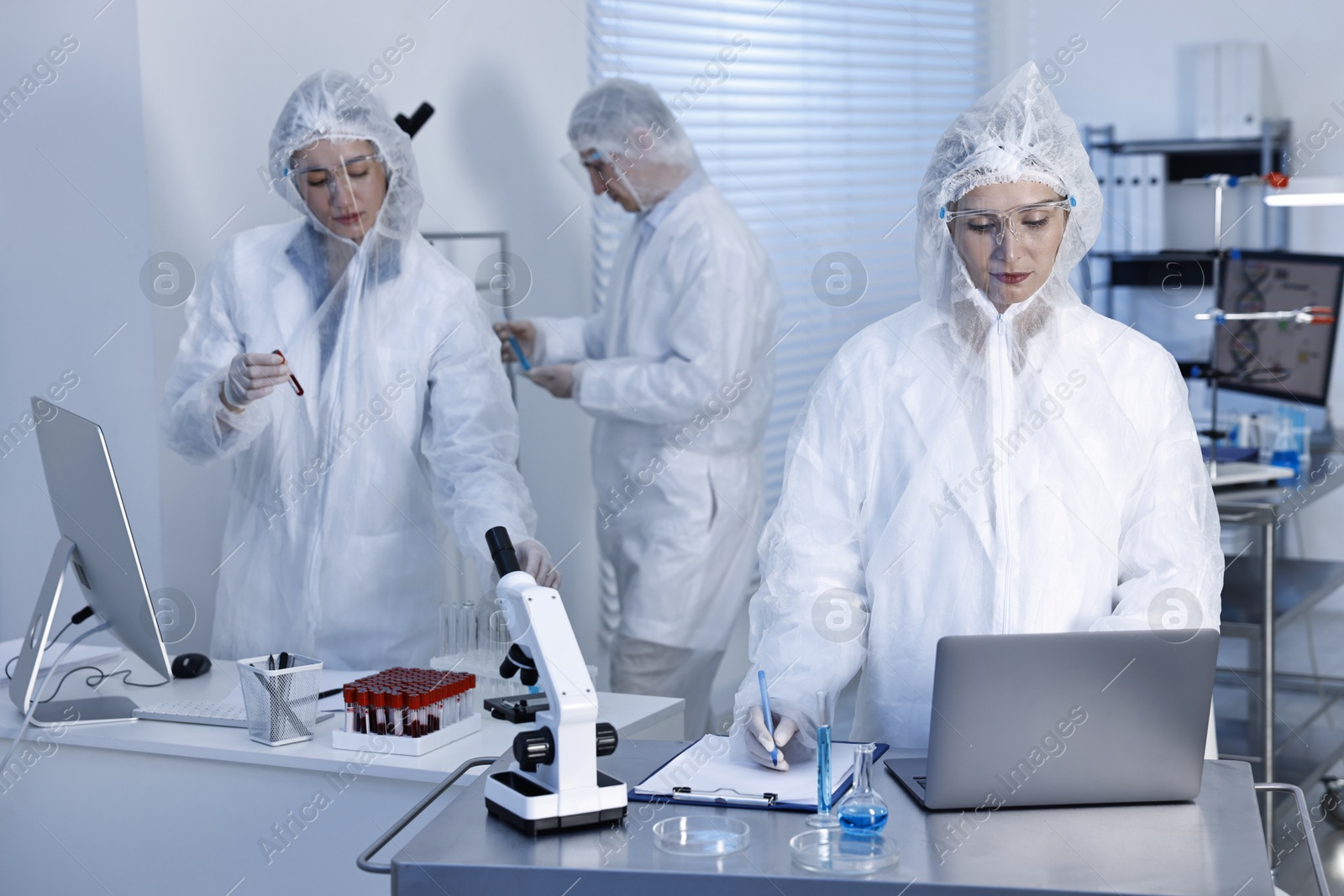 Photo of Scientists working with computers and samples in laboratory