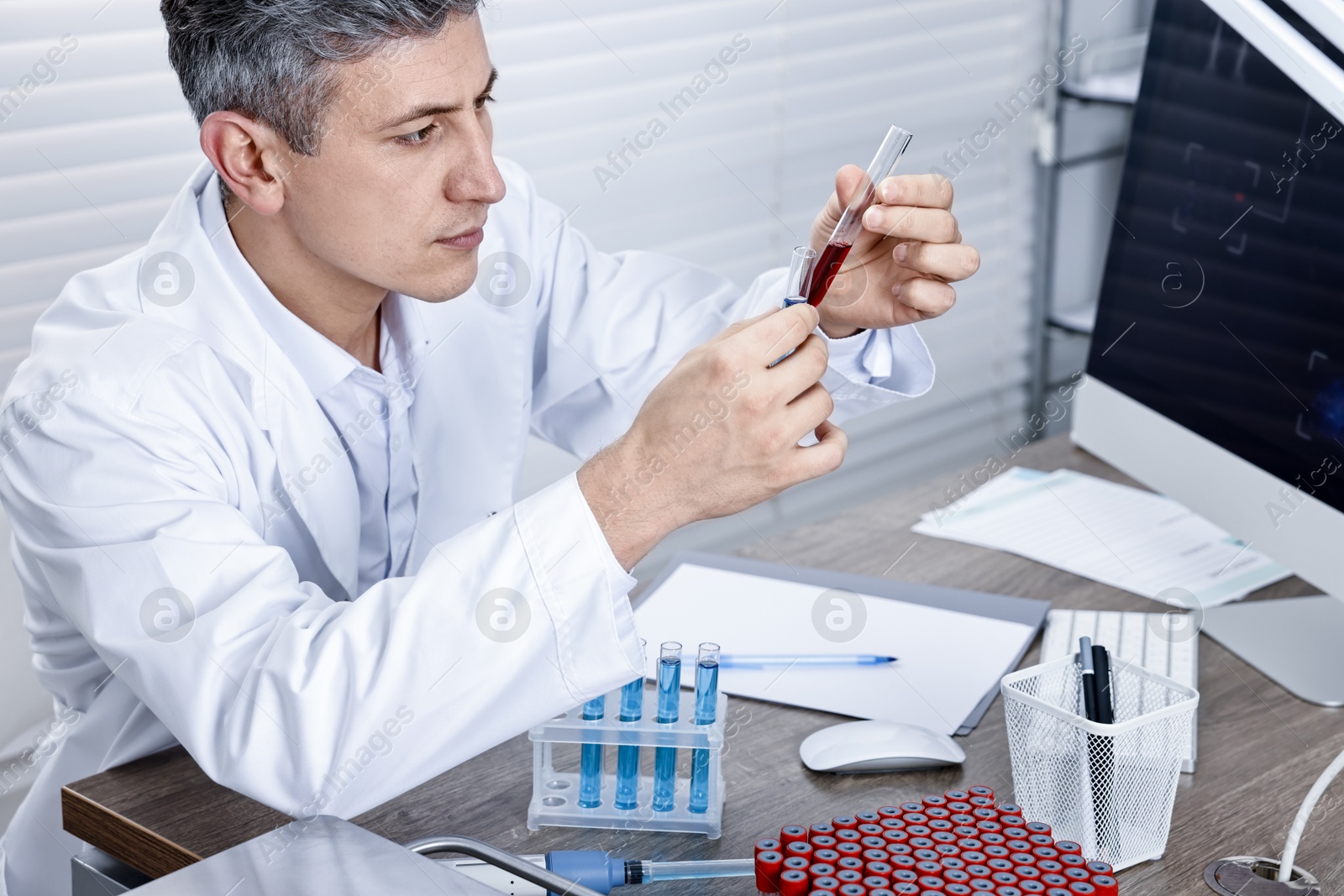 Photo of Scientist with test tubes working in laboratory