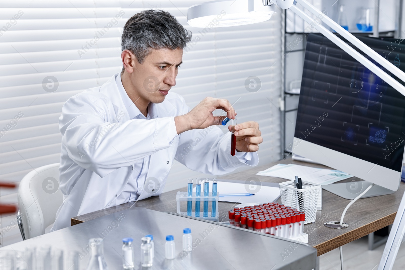 Photo of Scientist with test tubes working in laboratory