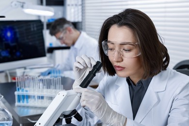 Photo of Scientist working with modern microscope in laboratory