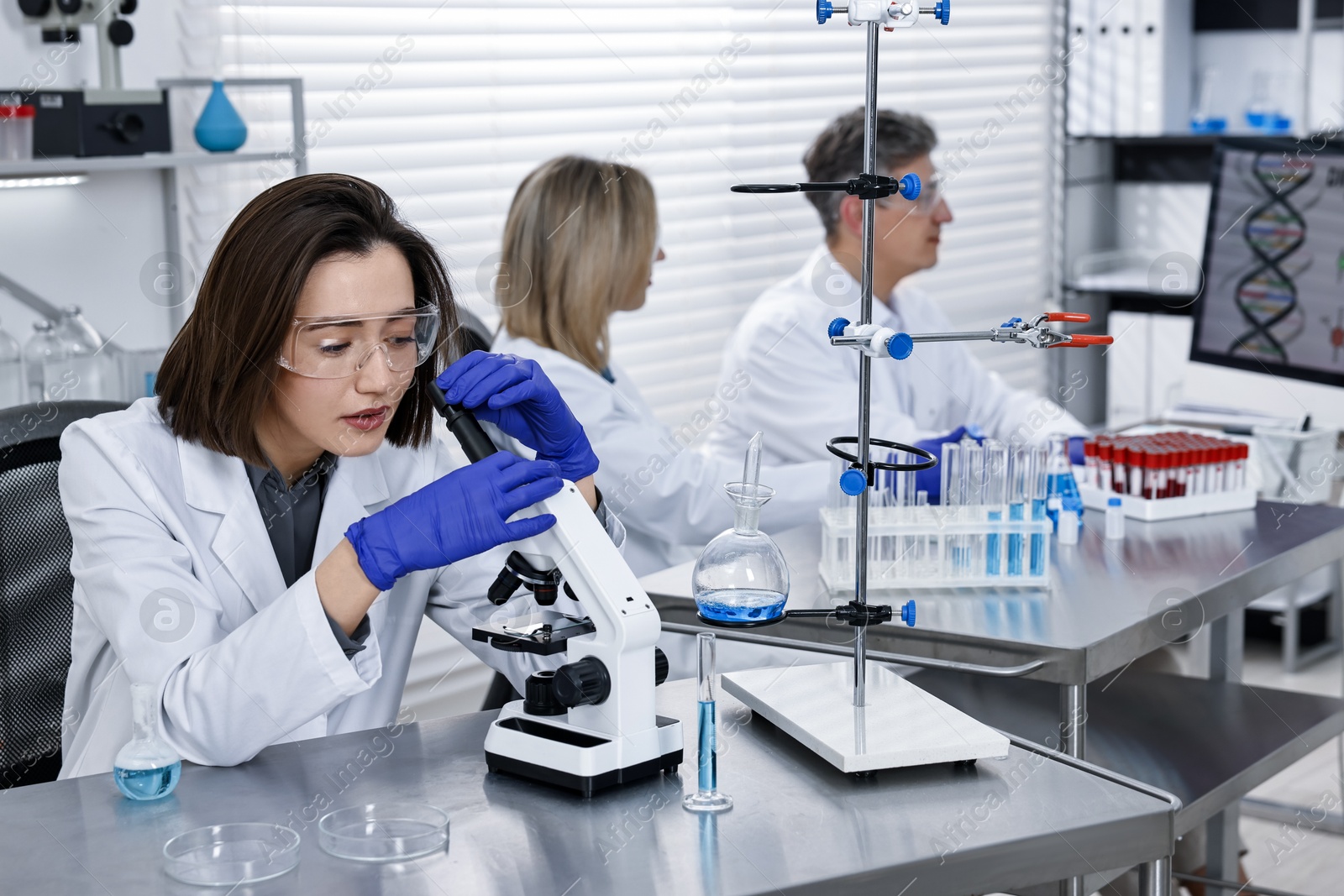 Photo of Scientist working with microscope at table in laboratory