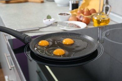 Photo of Cooking tasty eggs on frying pan in kitchen, closeup