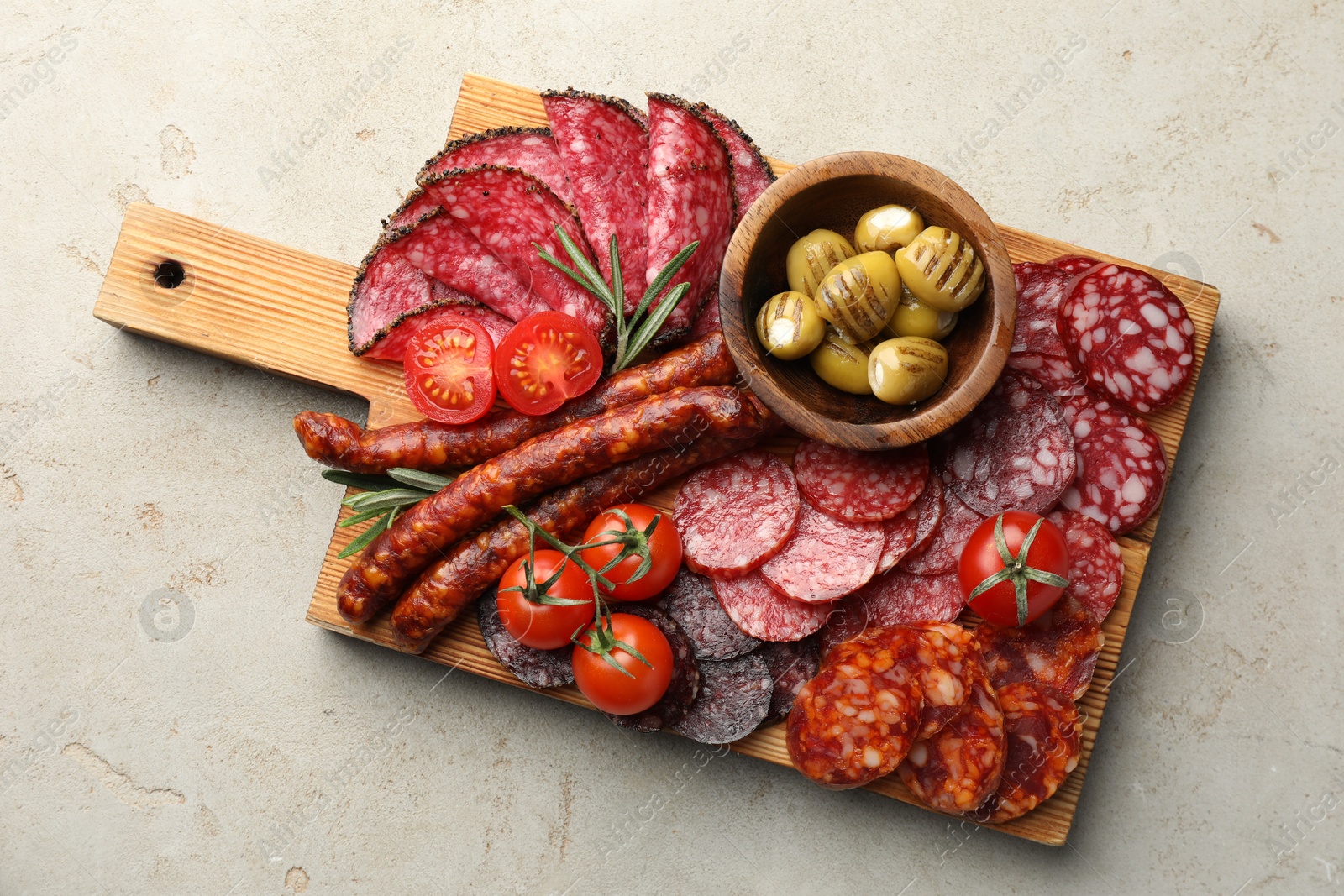 Photo of Different smoked sausages slices served on light table, top view