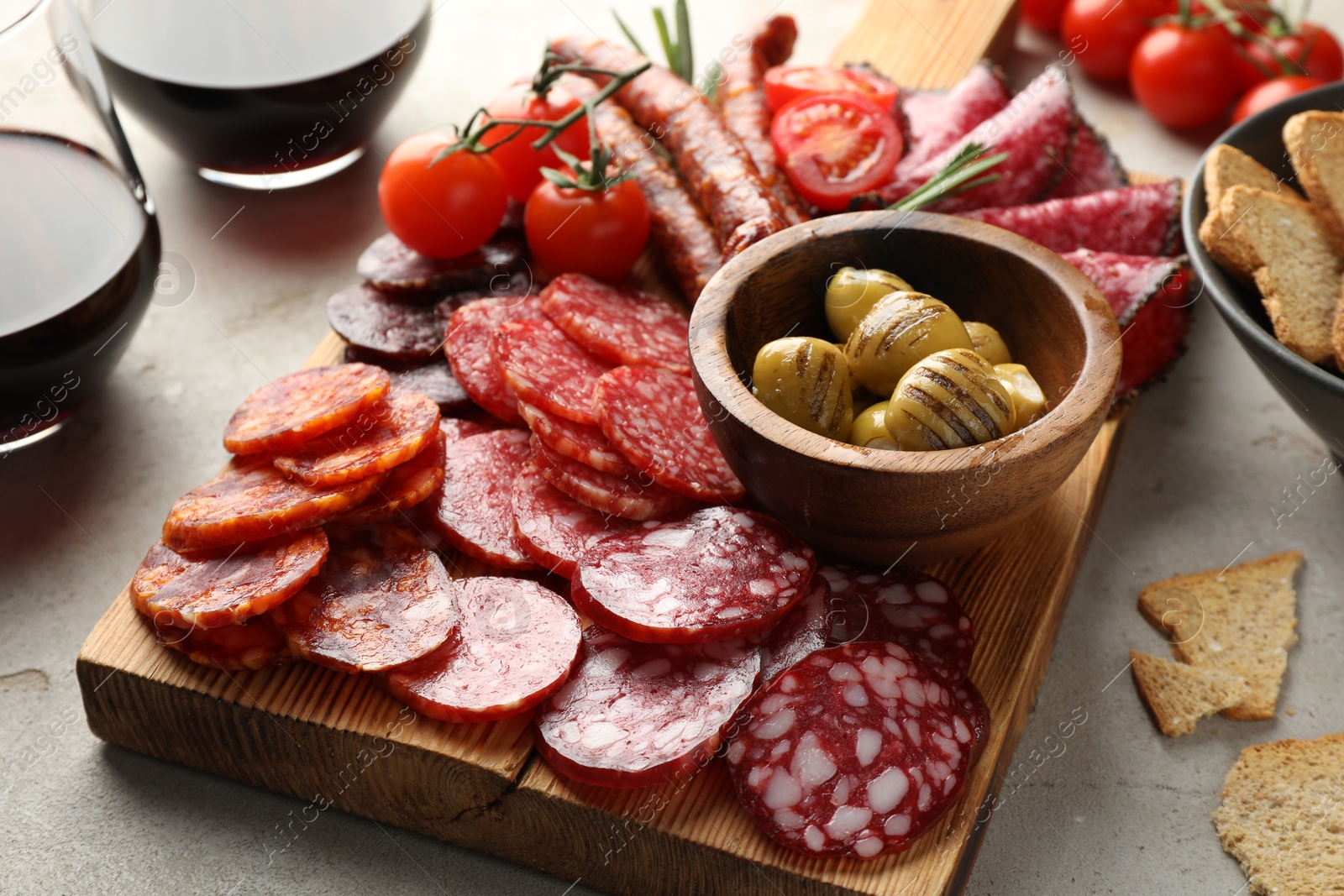 Photo of Different smoked sausages slices served on light table, closeup