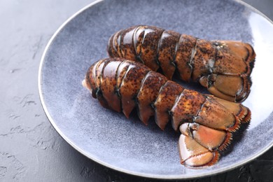 Raw lobster tails on black table, closeup