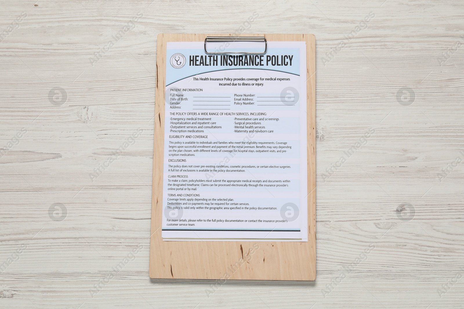 Photo of Health insurance policy form on light wooden table, top view