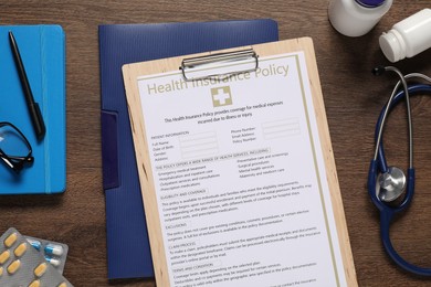 Flat lay composition with health insurance policy form on wooden table