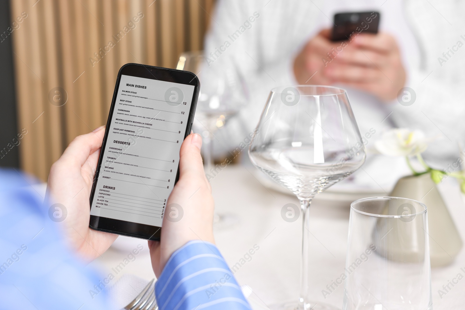 Photo of Couple choosing dishes from digital menu at restaurant, closeup