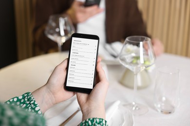 Photo of Couple choosing dishes from digital menu at restaurant, closeup