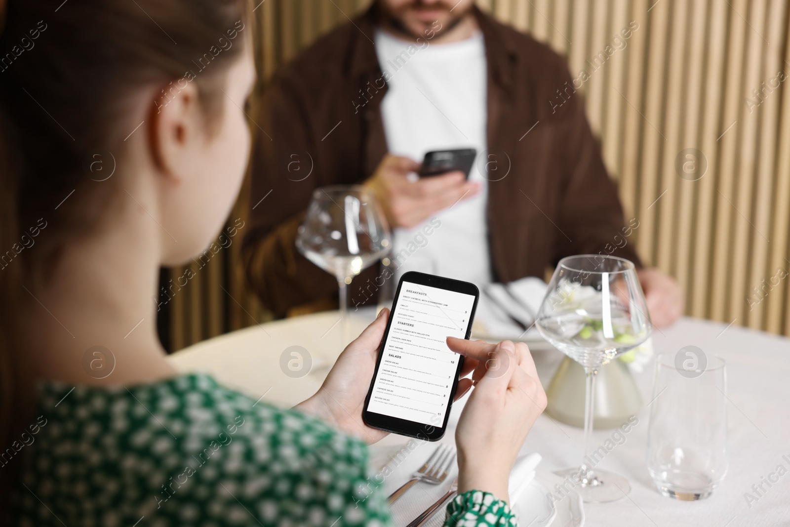 Photo of Couple choosing dishes from digital menu at restaurant, closeup