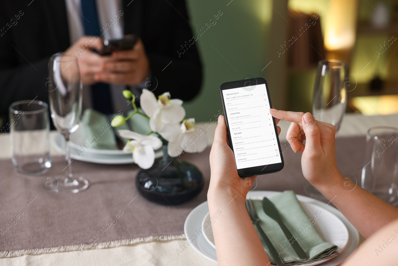 Photo of Couple choosing dishes from digital menu at restaurant, closeup