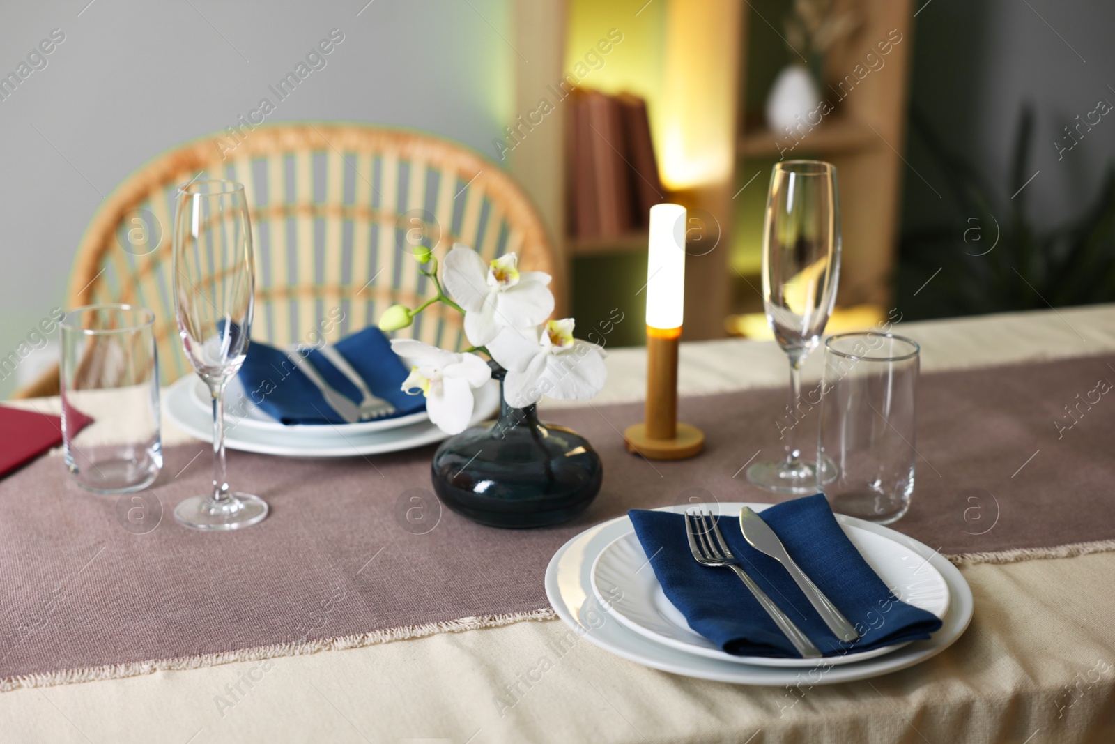 Photo of Stylish setting with cutlery, glasses and orchid flowers on table in restaurant