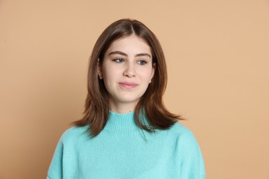 Photo of Portrait of beautiful teenage girl on beige background