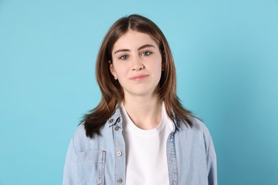 Photo of Portrait of beautiful teenage girl on light blue background