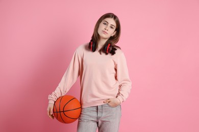 Photo of Portrait of teenage girl with headphones and basketball ball on pink background