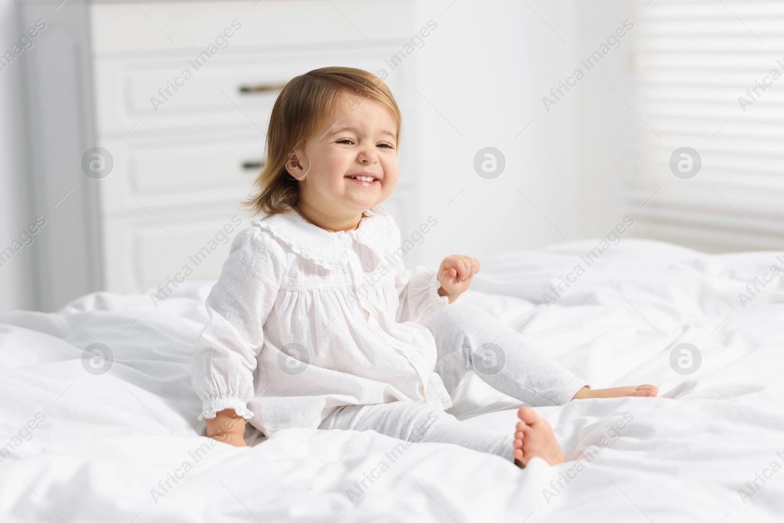 Photo of Cute little baby girl on bed at home