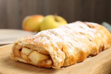 Delicious strudel with apples and powdered sugar on table, closeup