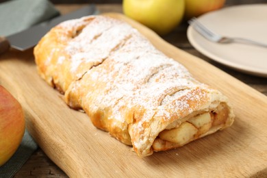 Delicious strudel with apples and powdered sugar on table, closeup