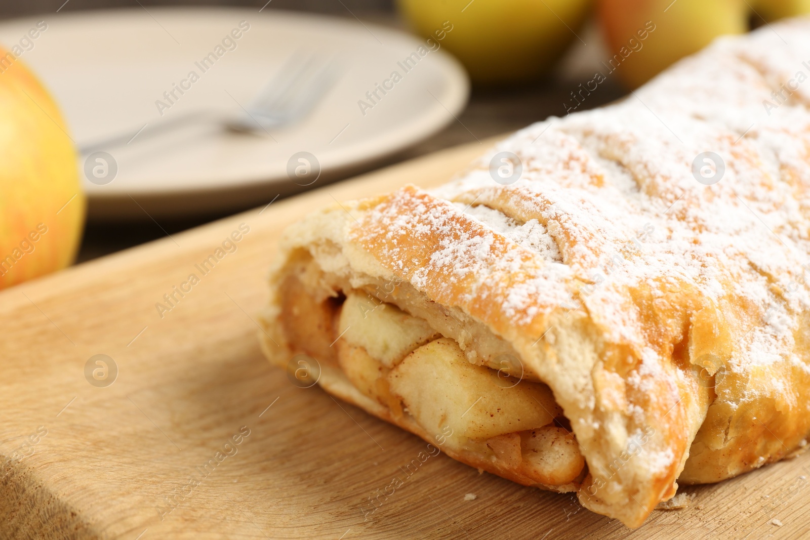 Photo of Delicious strudel with apples and powdered sugar on table, closeup. Space for text